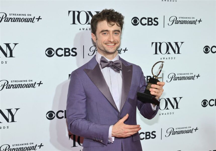 Daniel Radcliffe holding his Tony Award on stage | FAME DELIVERED