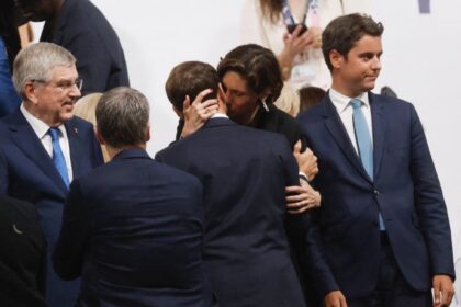 French minister of Sport Amélie Oudéa-Castéra (CR) hugs France's President Emmanuel Macron (CL) at the Trocadero following the opening ceremony of the Paris 2024 Olympic Games in Paris on July 26, 2024. (Photo by Odd ANDERSEN / AFP)(AFP)