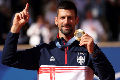 Serbia’s Novak Djokovic shows his gold medal after defeating Spain’s Carlos Alcaraz in the men’s singles tennis final at the Roland Garros stadium during the 2024 Summer Olympics, Sunday, Aug. 4, 2024, in Paris, France. Djokovic has won his first Olympic gold medal by beating Alcaraz 7-6 (3), 7-6 (2) in the 2024 Games men’s tennis singles final. (AP Photo/Louise Delmotte)